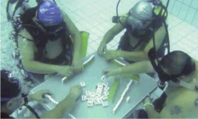 湖南持续高温 四位男子竟然背氧气罐水下打麻将